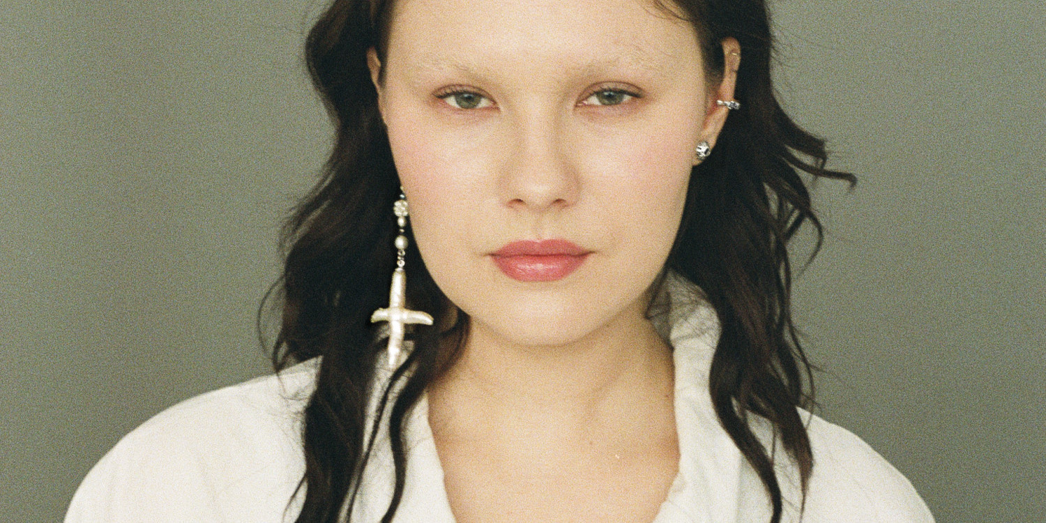 Asymmetrical freshwater cross pearl earring with sterling silver and black sapphire accents.